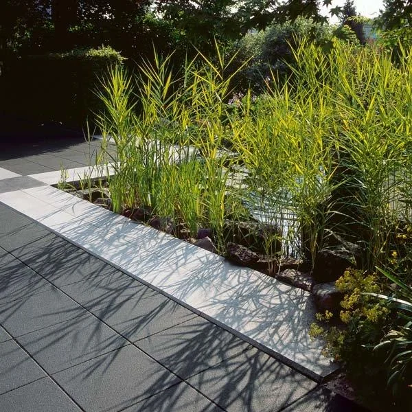 Losetas de concreto instaladas junto a un jardín